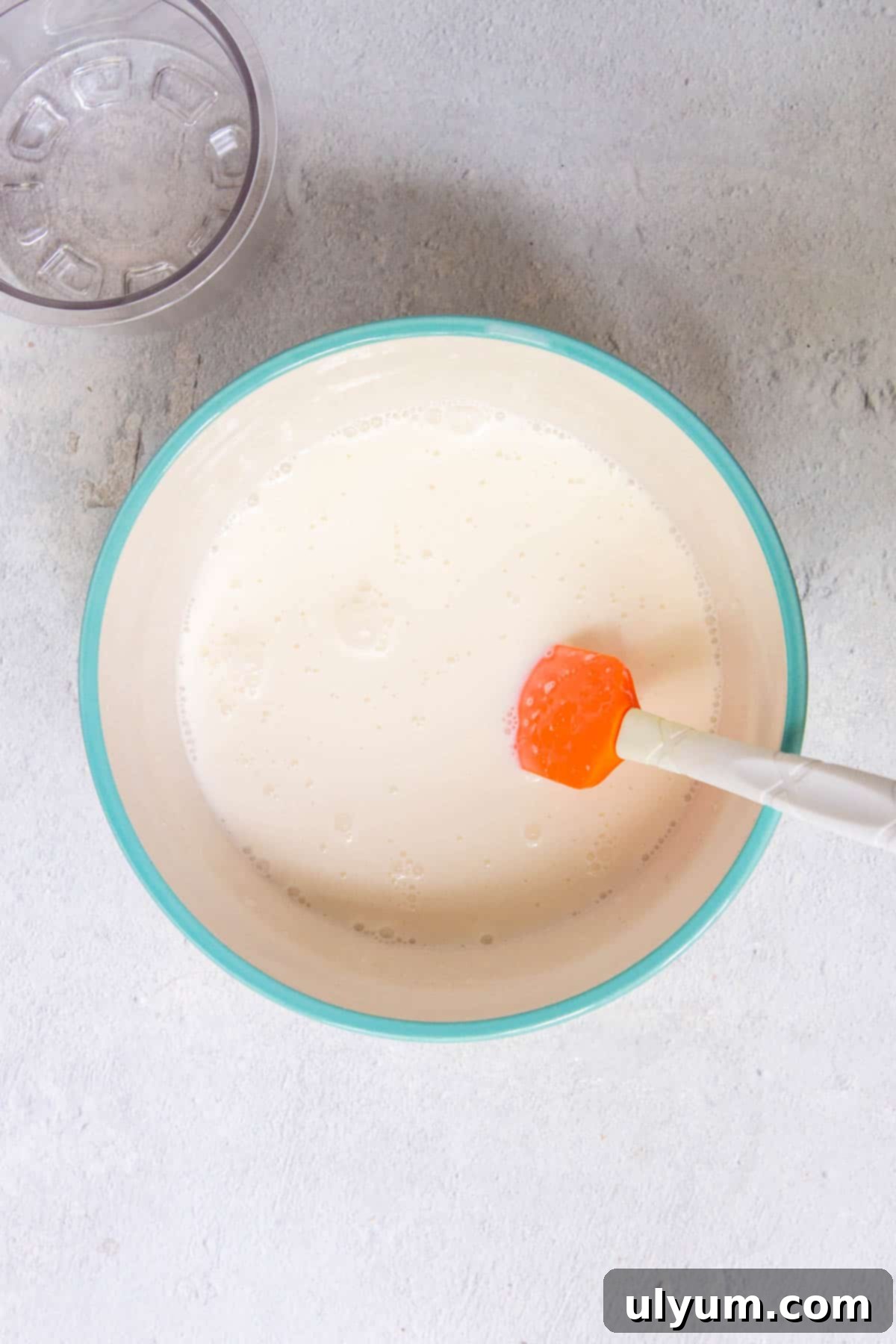 The vanilla ice cream mixture is fully incorporated in the mixing bowl and the sugar is fully dissolved.