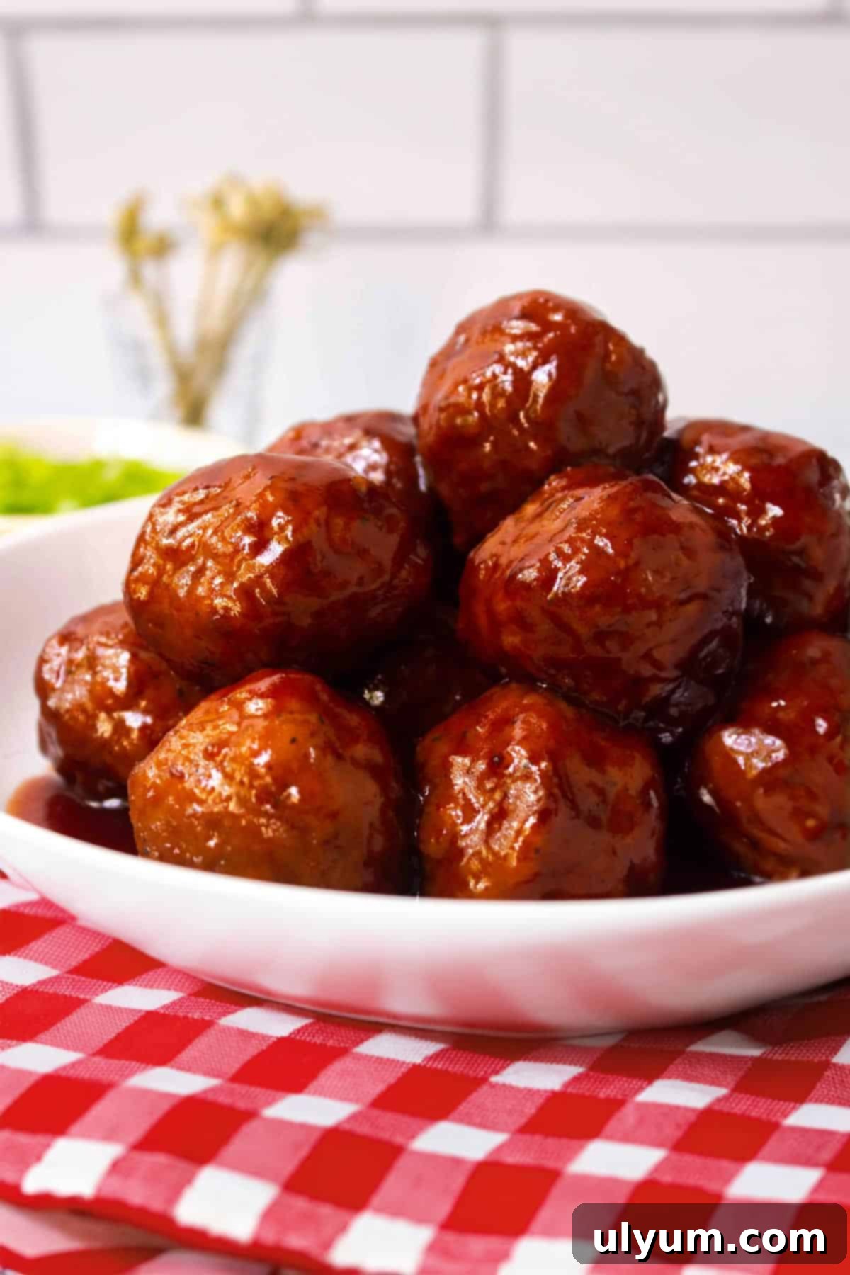 Effortless Frozen Meatball Meals 17 Ways 2 Grape jelly meatballs in a bowl, ready to be served as an appetizer.
