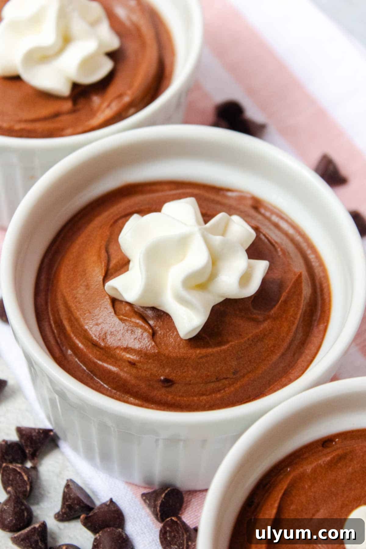 A serving of 2-Ingredient Chocolate Mousse topped with a dollop of fresh whipped cream in a ramekin