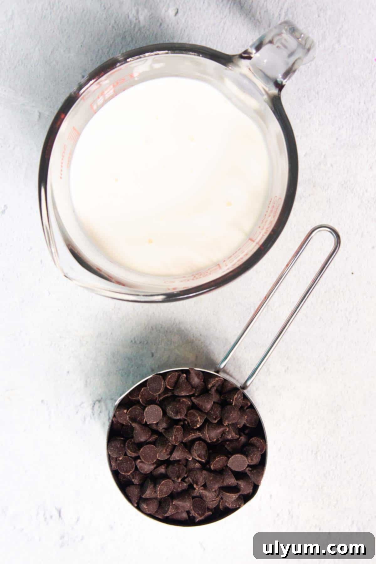 Two key ingredients for chocolate mousse: a bowl of chocolate chips and a carton of heavy cream