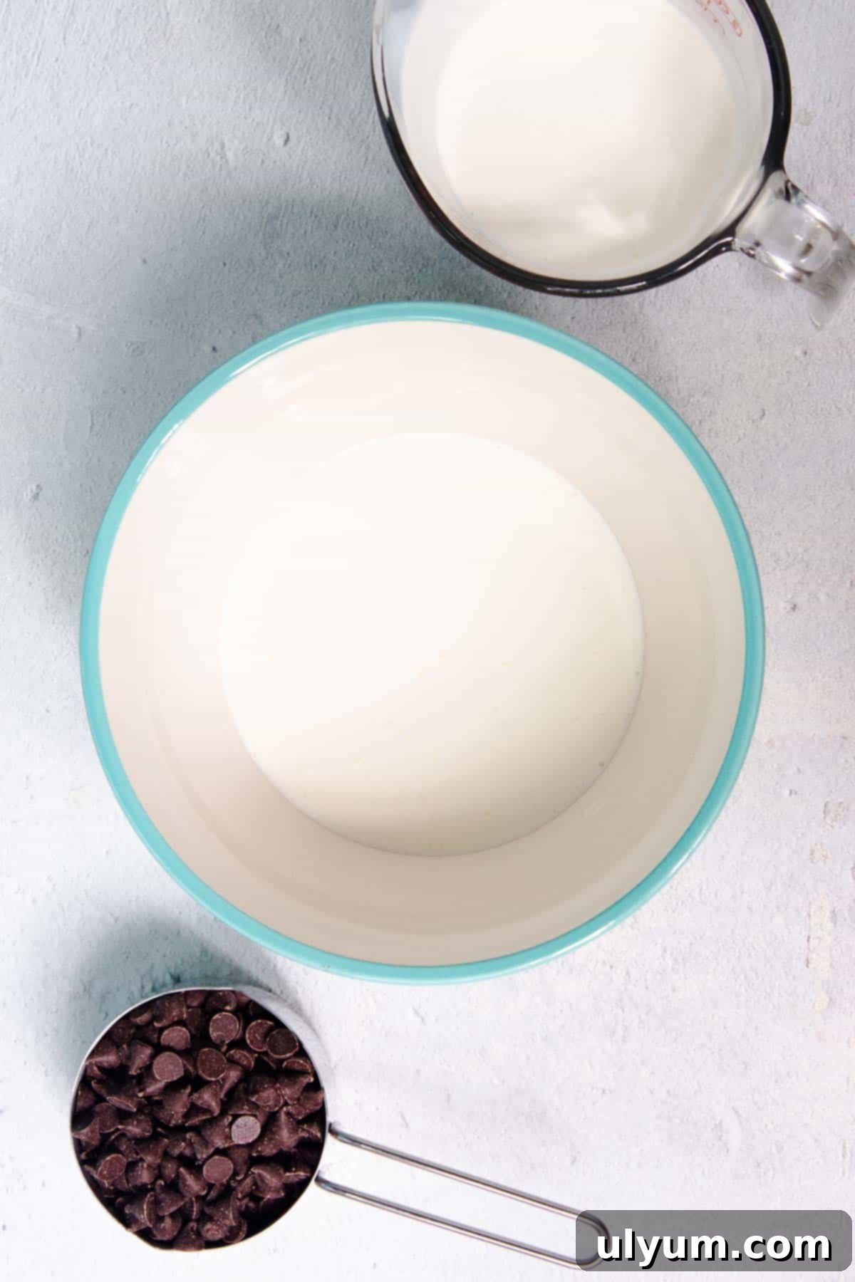 Heavy cream is carefully poured into a microwave-safe mixing bowl