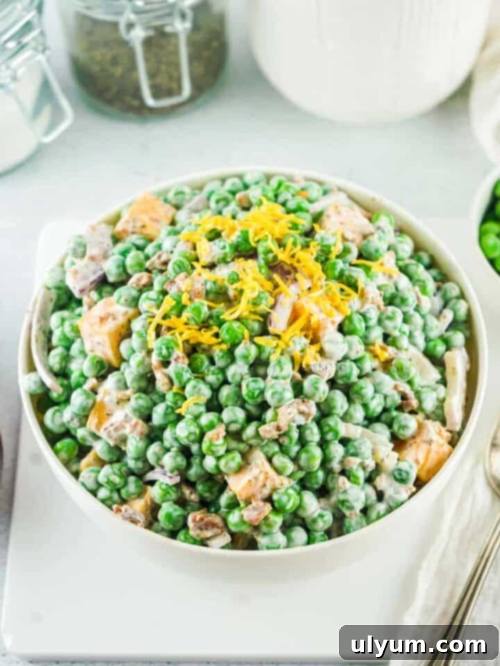 Old Fashioned Pea Salad, a versatile side with peas, cheese, red onion, bacon, and a creamy homemade dressing.