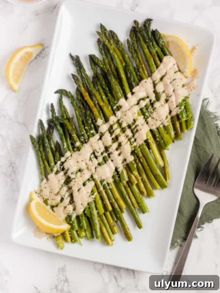 Easy Roasted Asparagus with Lemon Tahini Sauce, a simple yet elegant vegetable side.