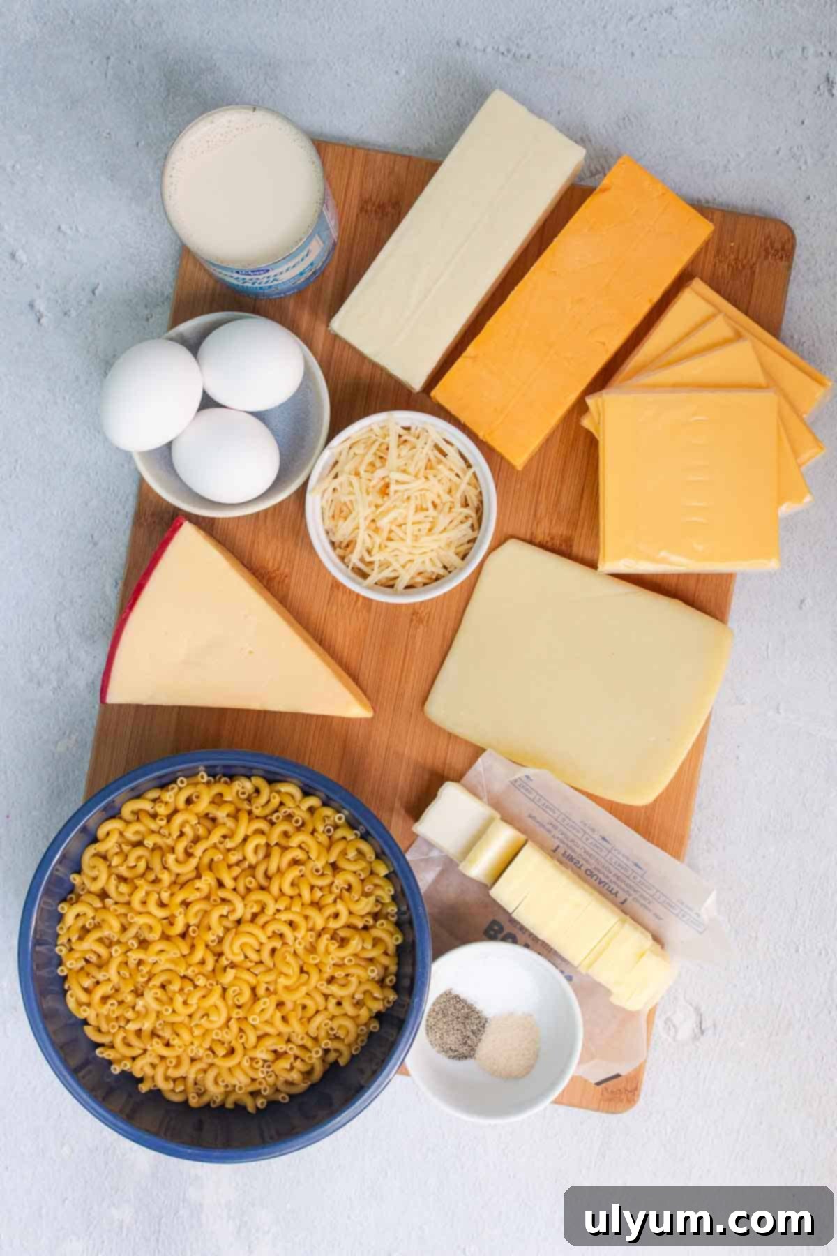 Homestyle Southern Baked Mac and Cheese 3 Assortment of fresh ingredients for 6 Cheese Mac and Cheese including pasta, various cheeses, eggs, milk, and seasonings.