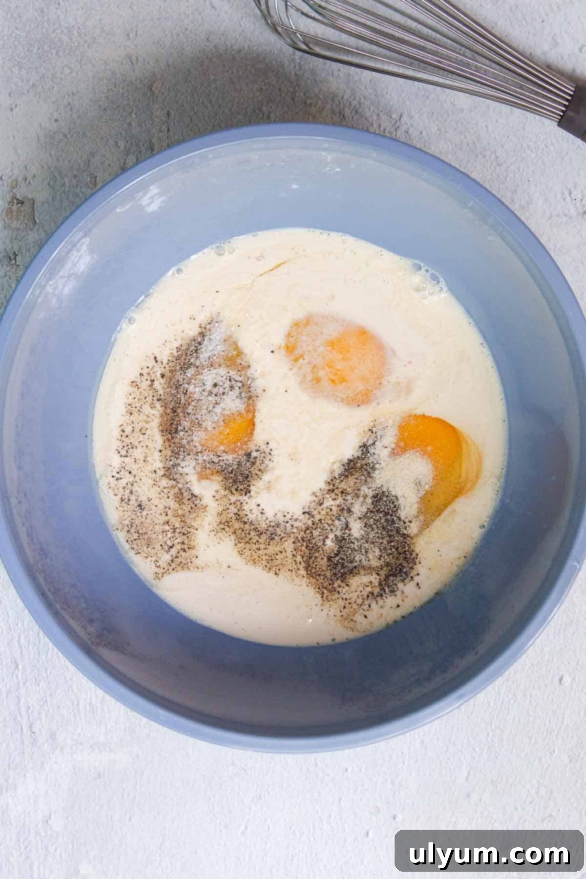 Egg and evaporated milk mixture in a mixing bowl, ready to be combined with other ingredients.