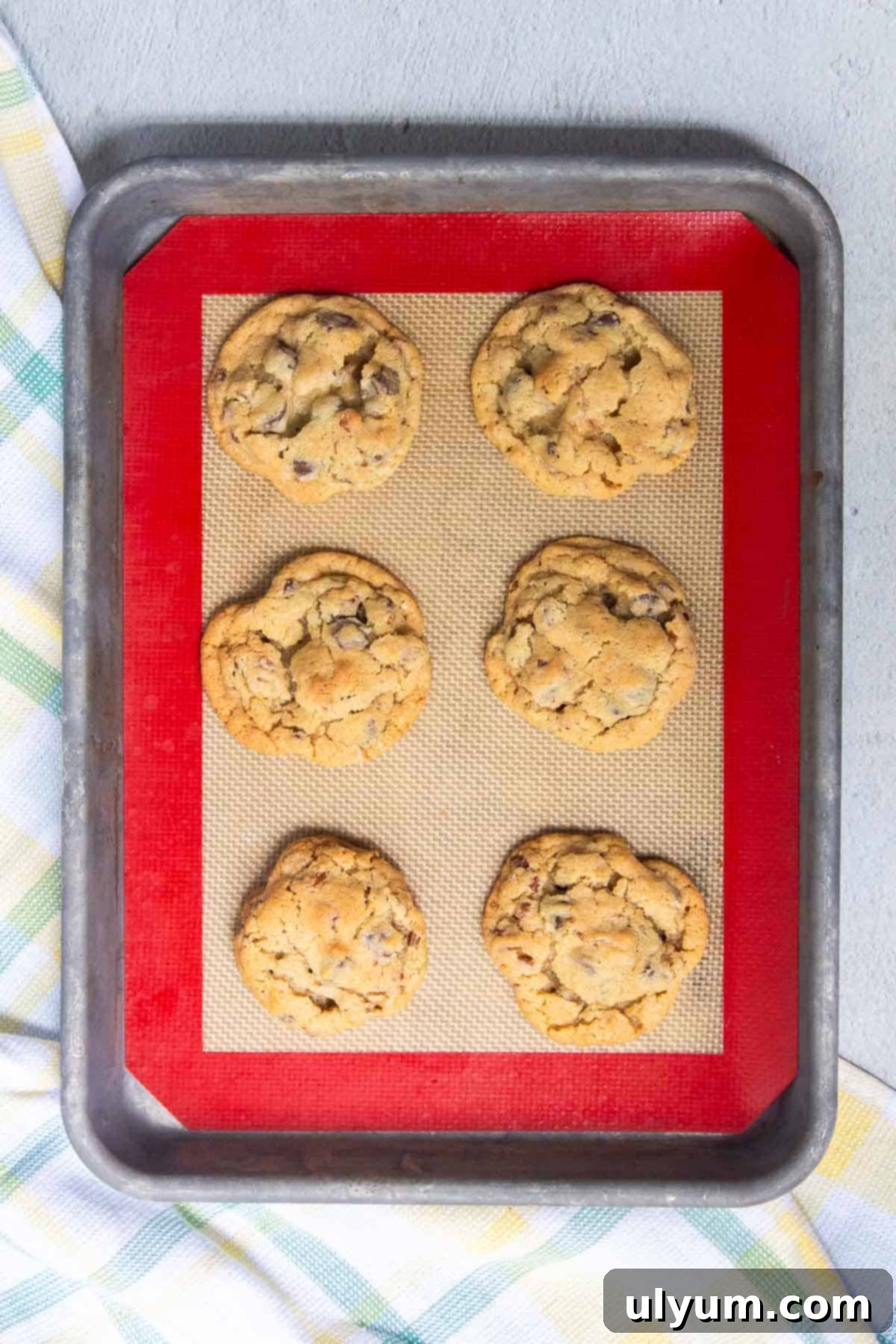 Crisco Ultimate Chocolate Chip Cookies baked on a baking sheet with a silicone baking mat