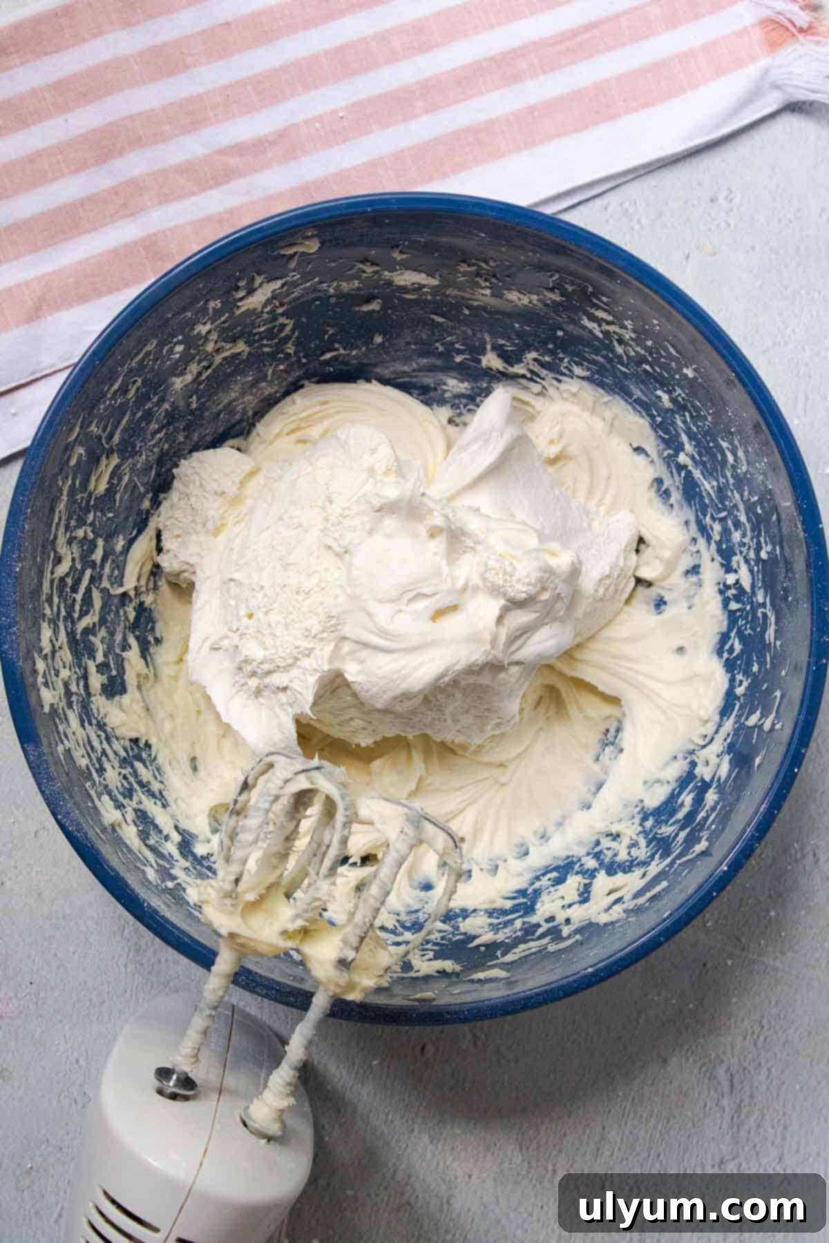 Cool Whip Cream Cheese Frosting 8 Thawed Cool Whip is gently folded into the cream cheese and powdered sugar mixture in a mixing bowl.