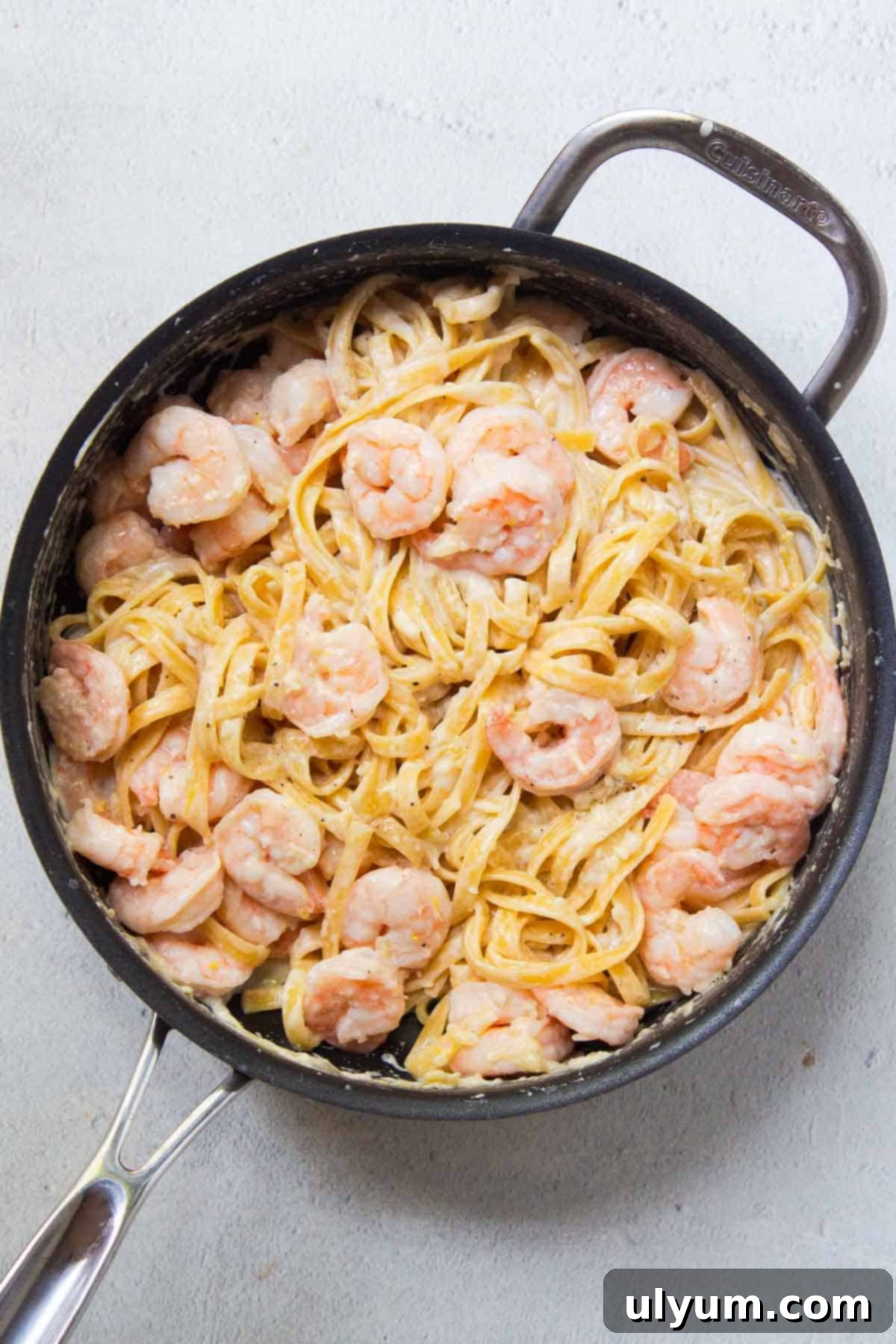 Shrimp is mixed in with the cooked pasta