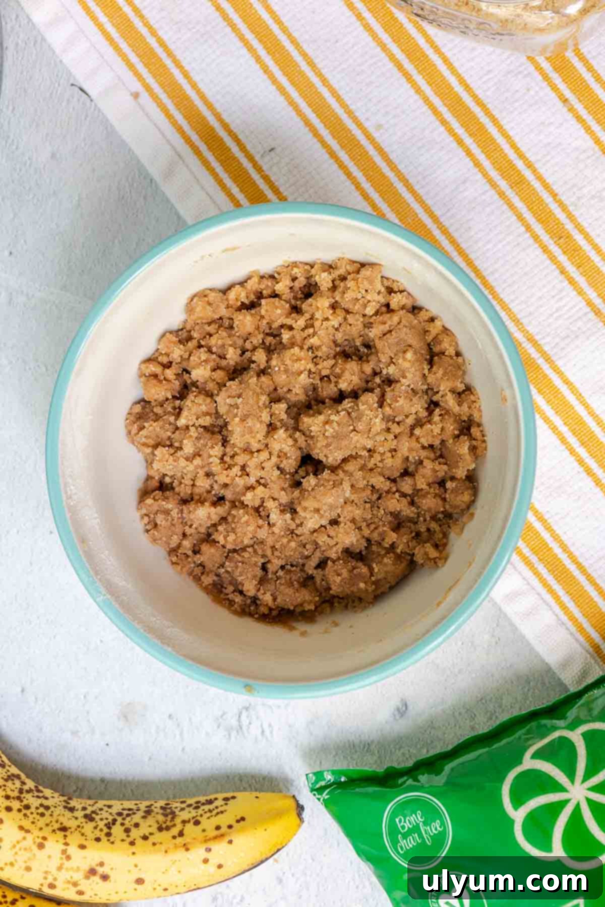 The crumble topping mixture, showing a delightful blend of large and small crumbs after the melted butter has been incorporated with a fork.