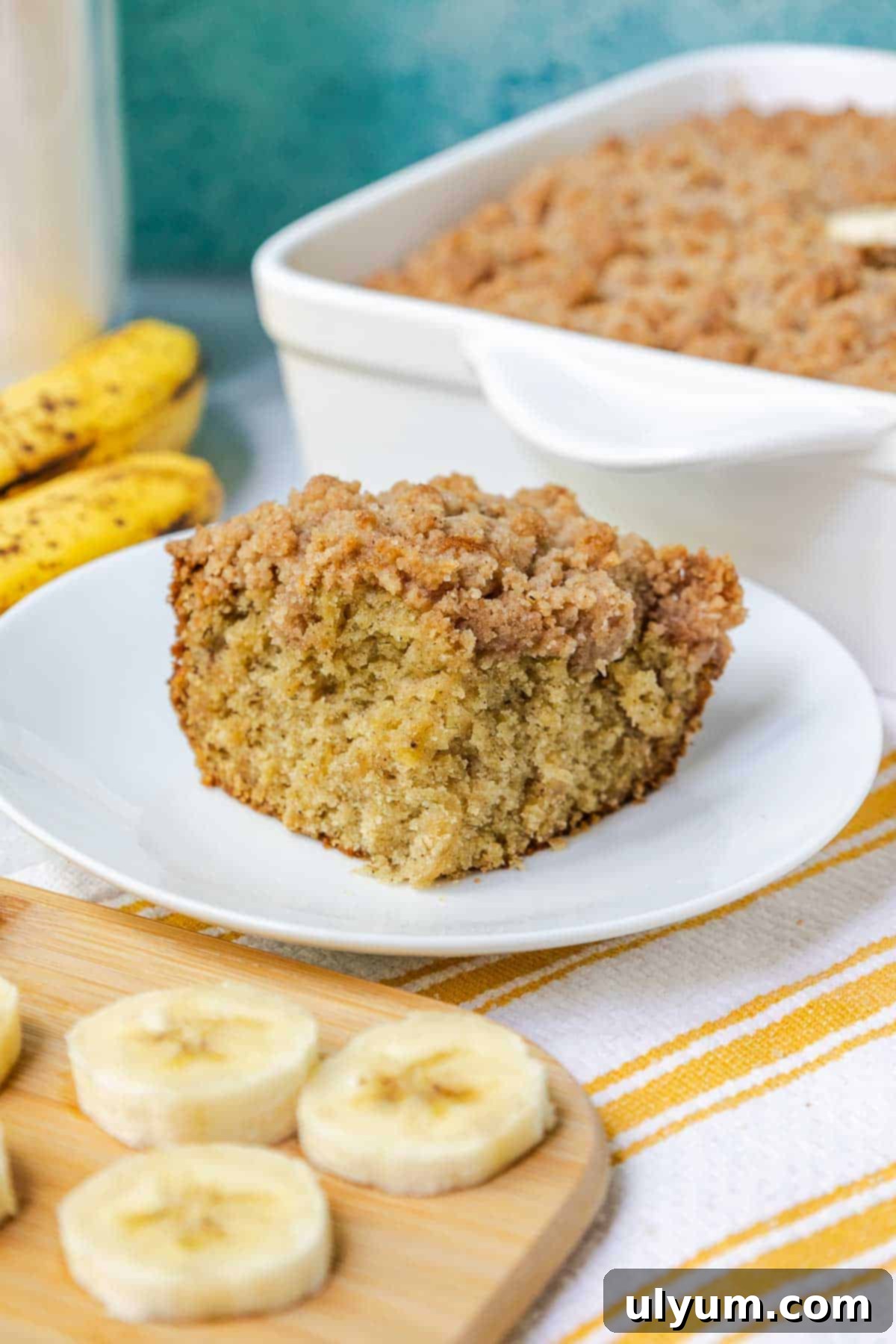 A perfectly baked slice of banana coffee cake, showcasing its moist interior, golden crumble topping, and inviting texture.