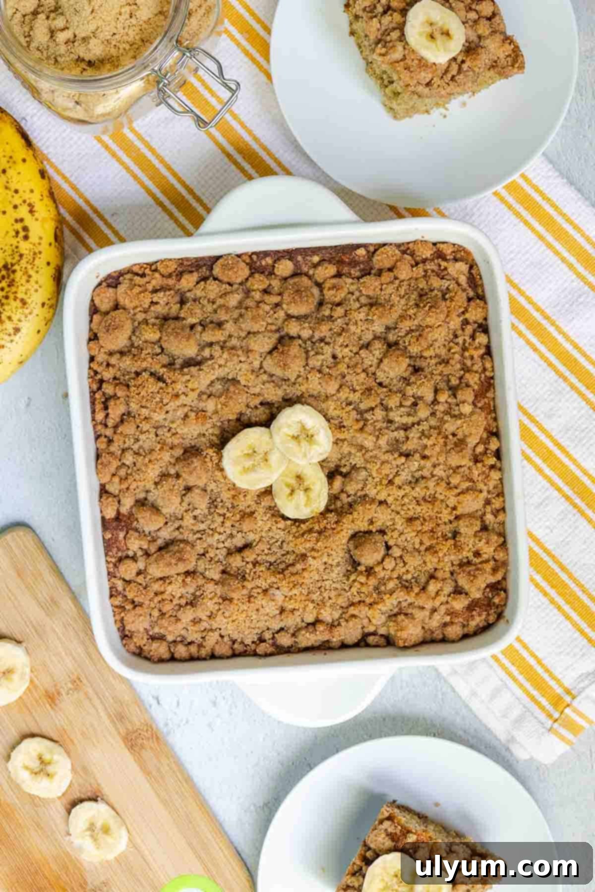The full banana coffee cake in an 8x8 baking dish, with a golden-brown crumble topping, ready to be sliced and served.