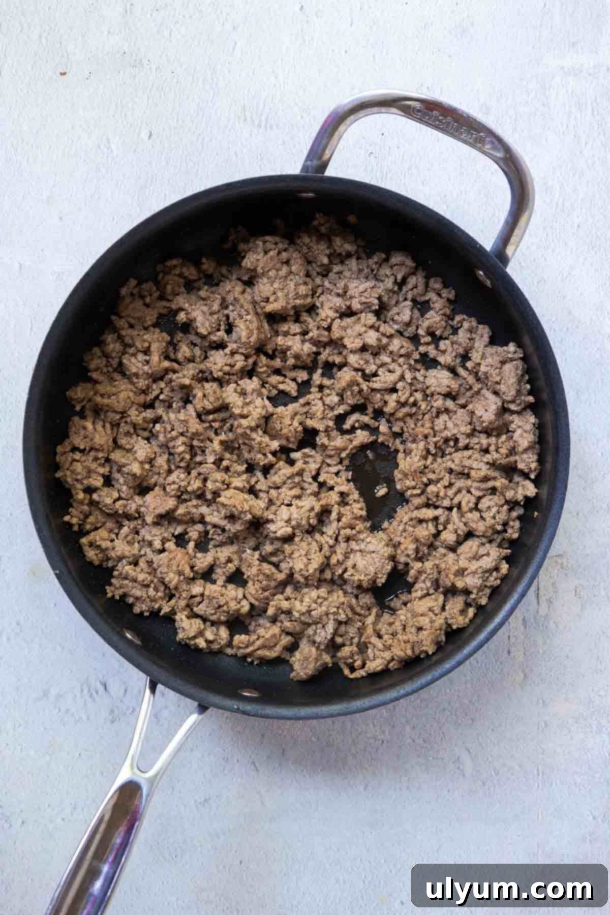 Browned ground beef in a large skillet, ready for the next step of the casserole preparation.