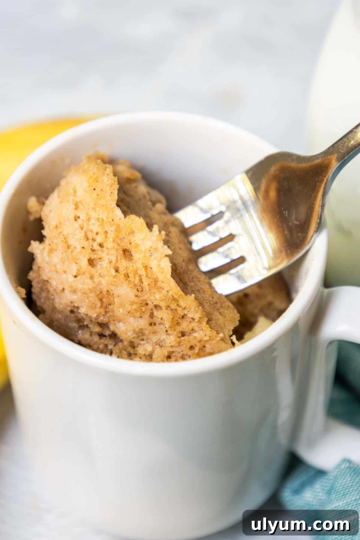 A bite of banana mug cake on a fork to show the banana bread-like texture.