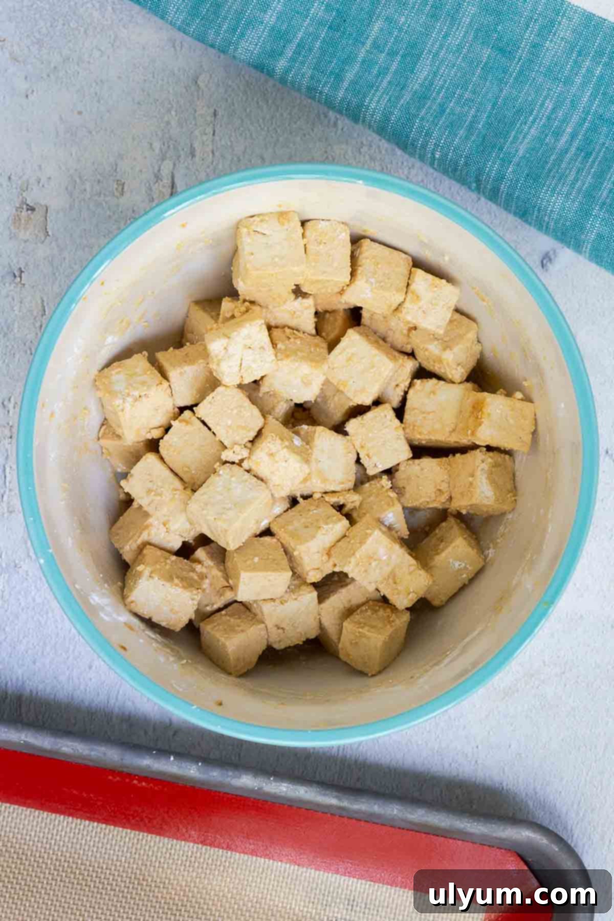 The marinated tofu is uniformly coated with corn starch, ready for baking.