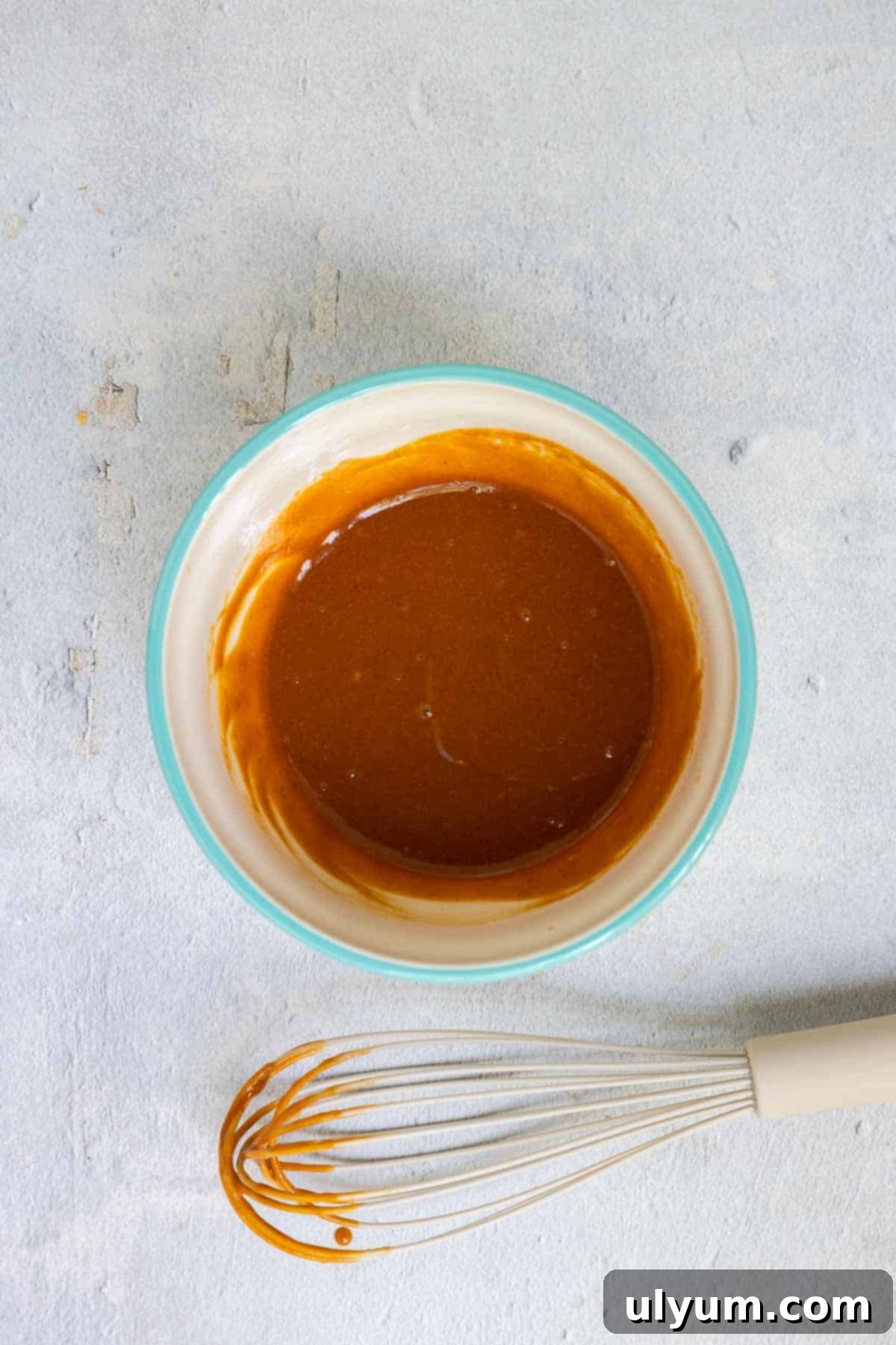Peanut sauce is whisked until perfectly smooth in a small mixing bowl, ready to coat the tofu.