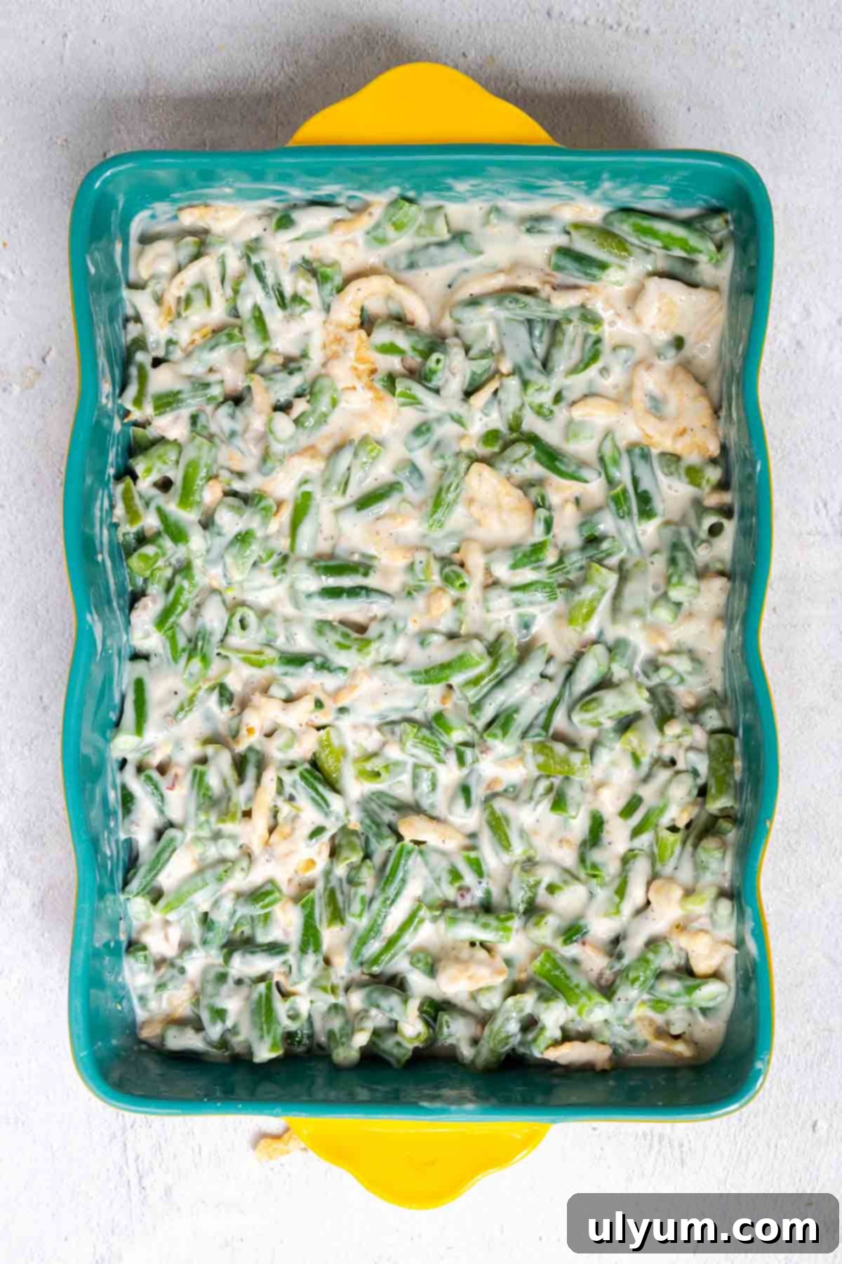 Holiday-Sized Green Bean Casserole 4 The green bean casserole filling is spread evenly into the bottom of a 9 by 13 inch casserole dish.