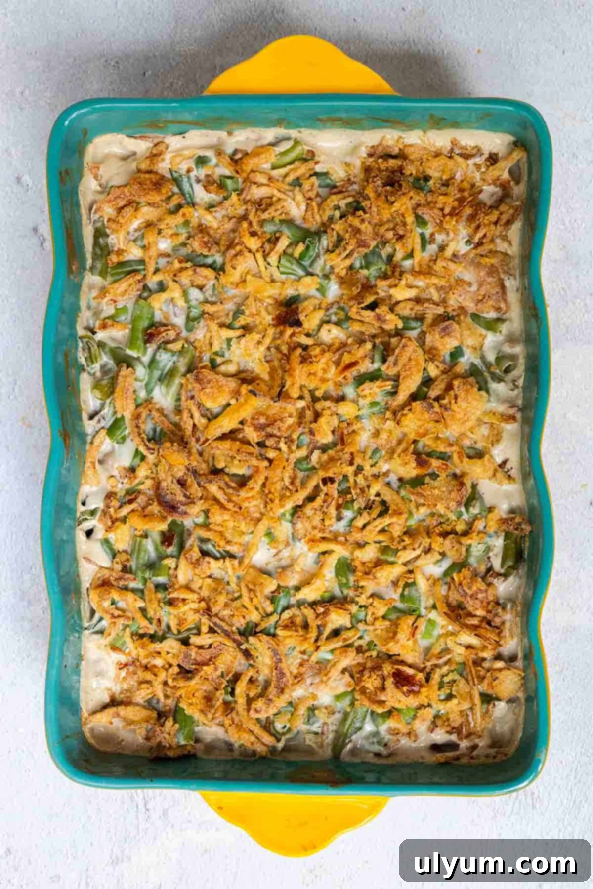 Holiday-Sized Green Bean Casserole 7 Green bean casserole topped with crispy fried onions is baked until the onions are golden.