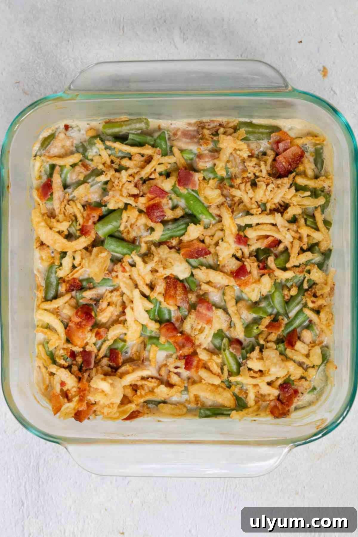 Crispy fried onions and bacon are added and cooked until the onions are golden brown.