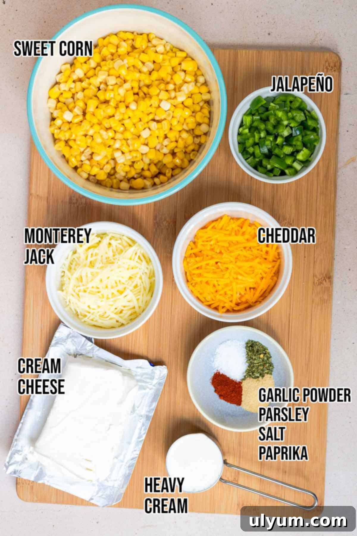 Creamy Jalapeño Corn Casserole ingredients: cream cheese, heavy cream, jalapeños, corn, pepper jack, sharp cheddar, garlic powder, dried parsley, salt, and paprika.