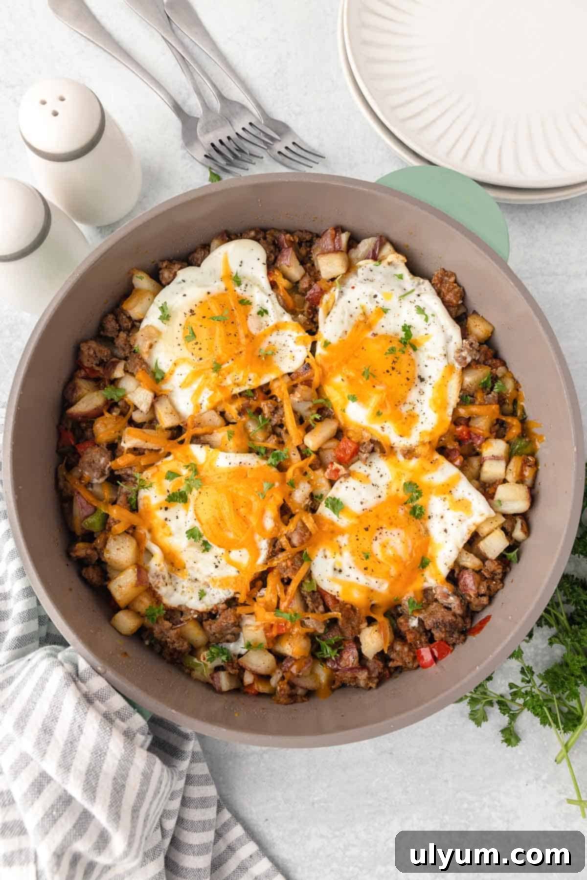 The cooked eggs are topped with cheese and fresh parsley.