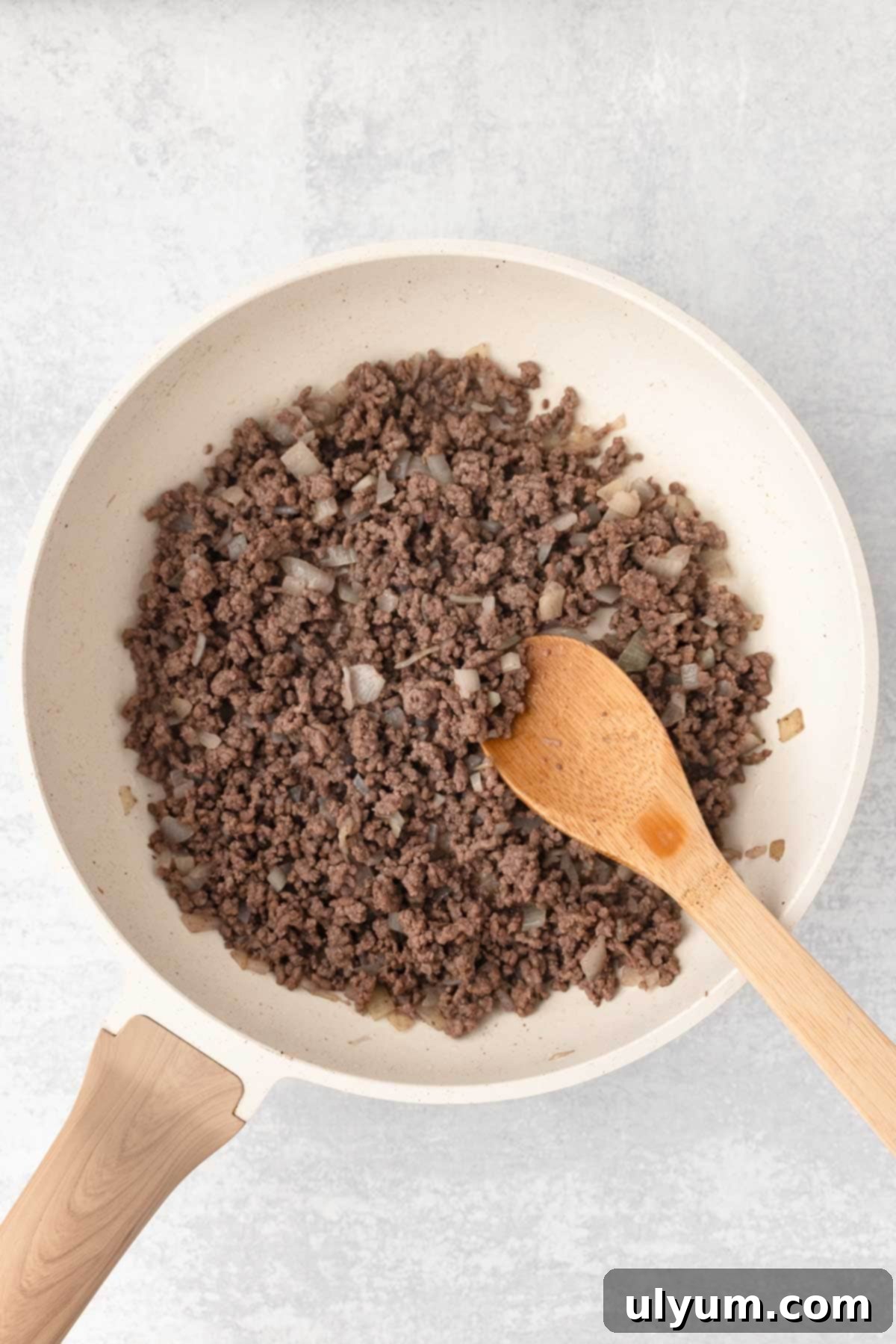Ground beef and diced onion cooked in a large skillet until the beef is browned and the onions are translucent.