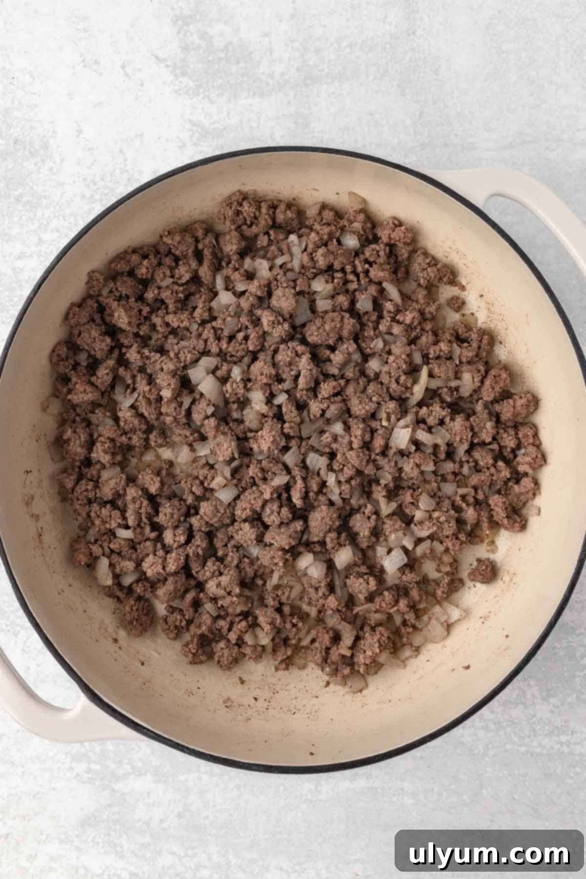 The Ultimate One-Pot Cheesy Taco Pasta 5 Ground beef and onions are cooked in a large pot until the ground beef is browned.