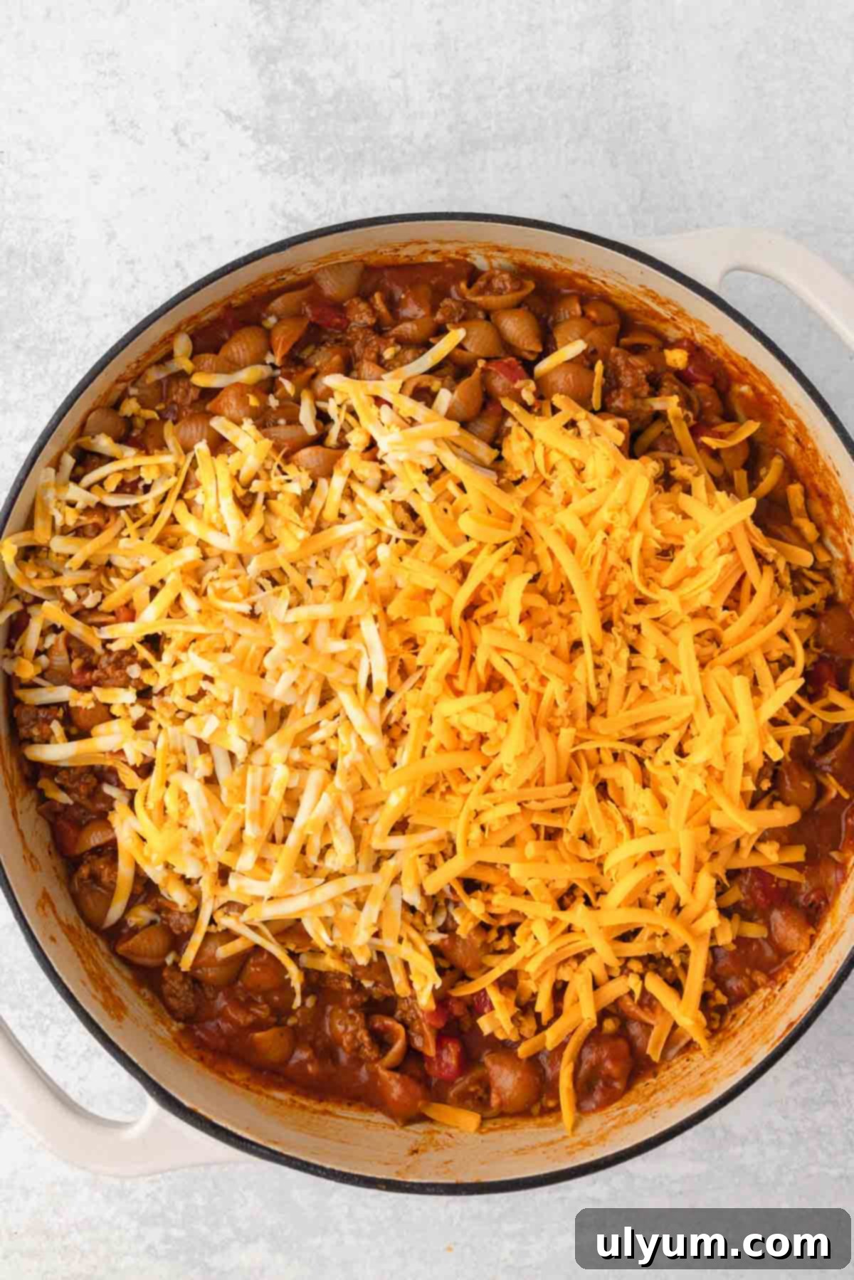 The Ultimate One-Pot Cheesy Taco Pasta 9 Cheese is added to the pot of pasta.