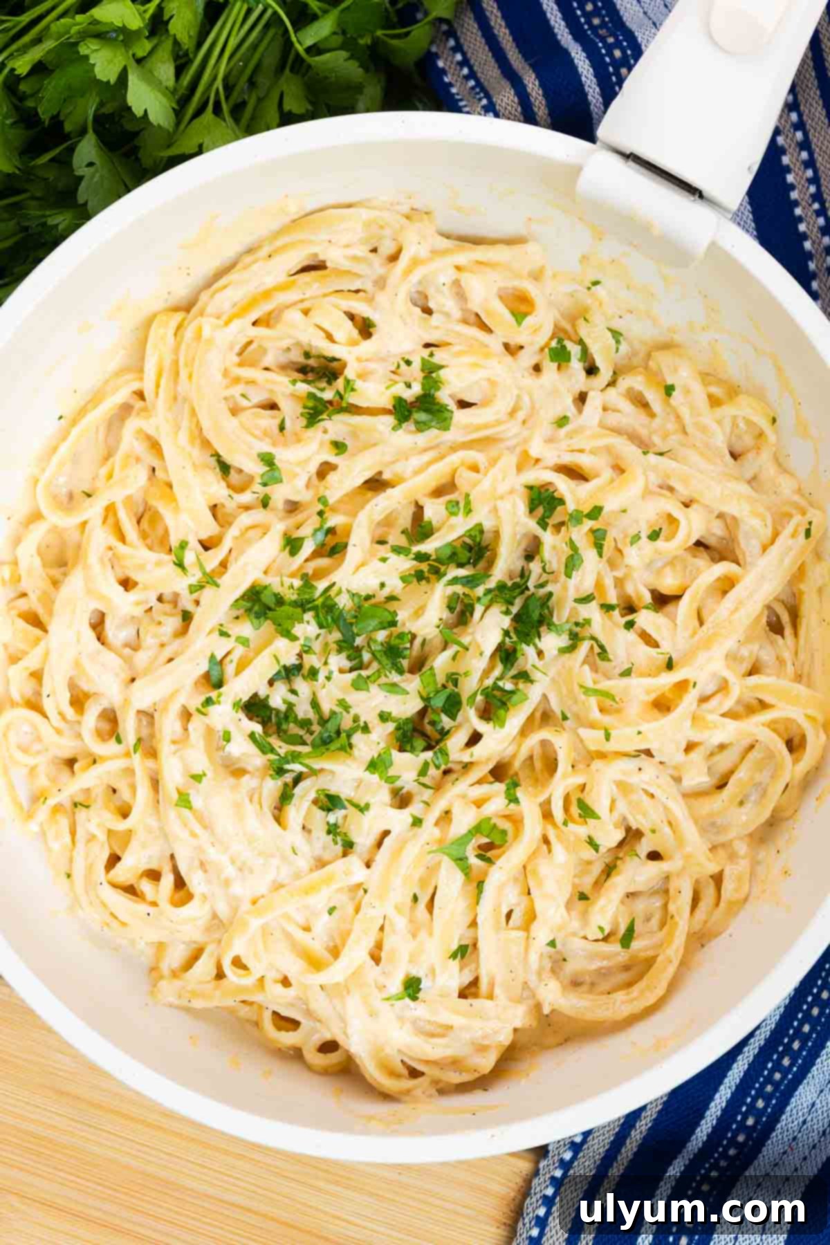 Cajun fettuccine Alfredo in a large skillet garnished with fresh parsley.