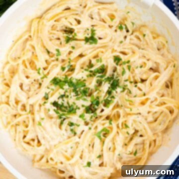 Cajun fettuccine Alfredo in a large skillet garnished with fresh parsley.