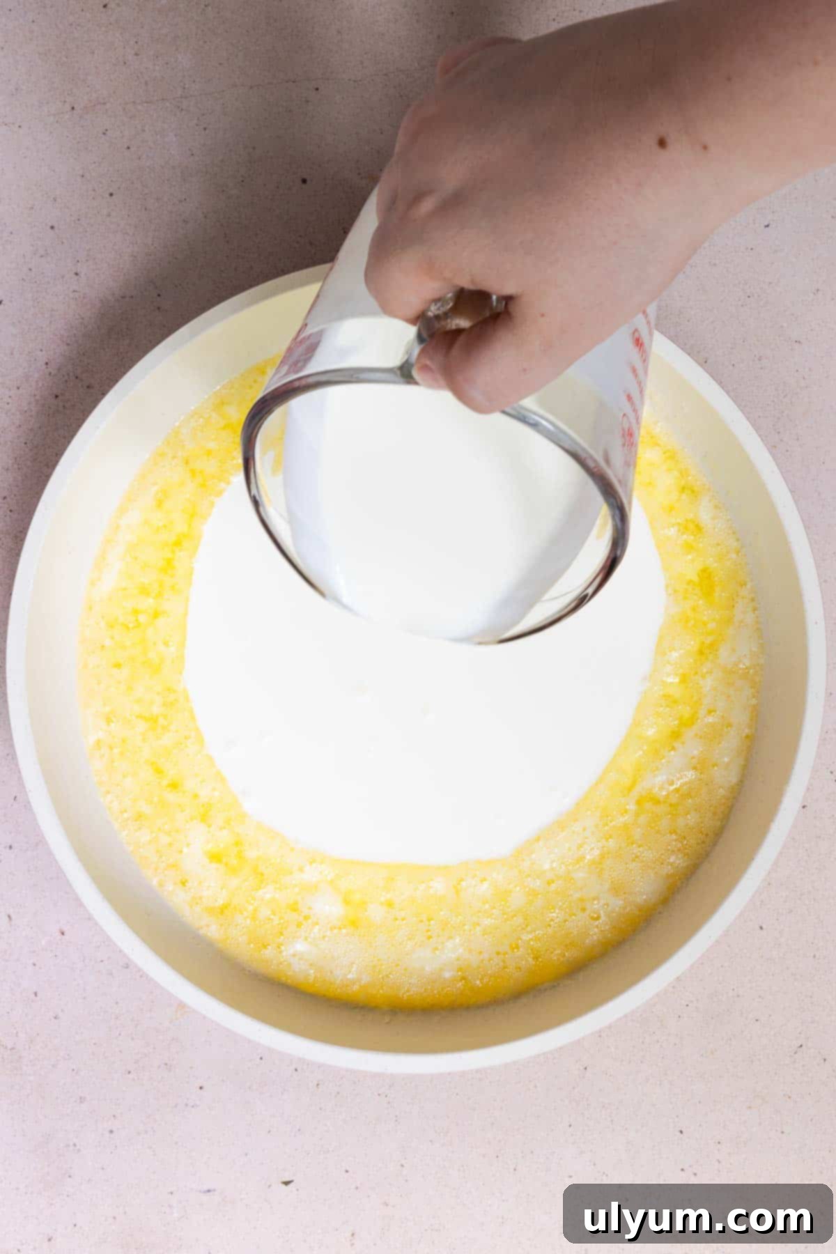 Heavy cream poured into melted butter in a large skillet.