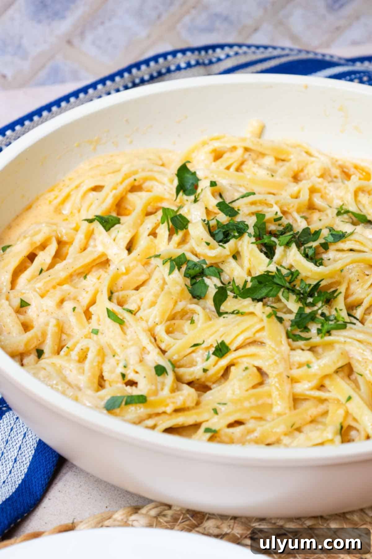 Cooked fettuccine coated in Cajun Alfredo sauce and garnished with fresh parsley.