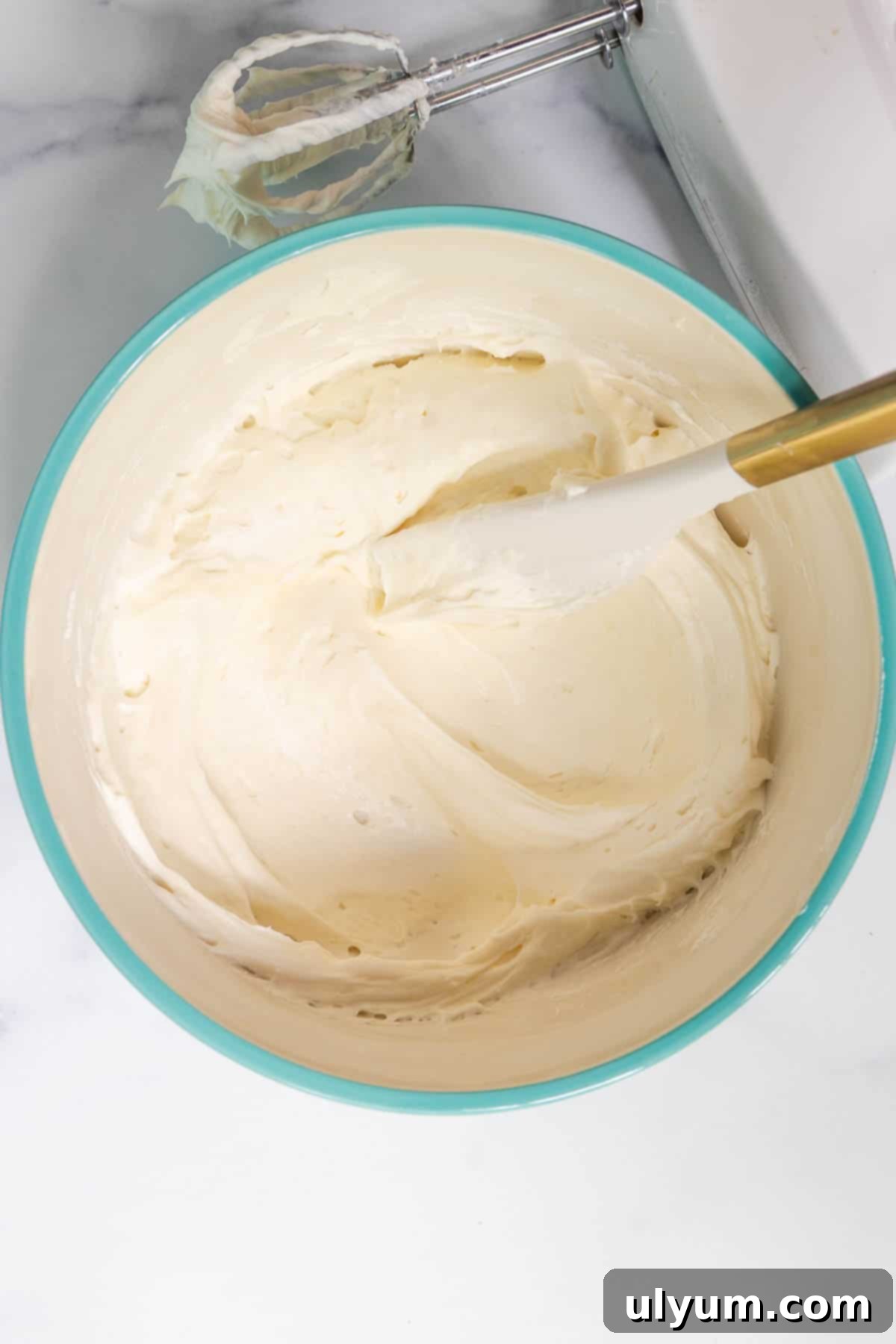 In a large mixing bowl, the cream cheese mixture and the whipped cream are folded together with a silicone spatula.