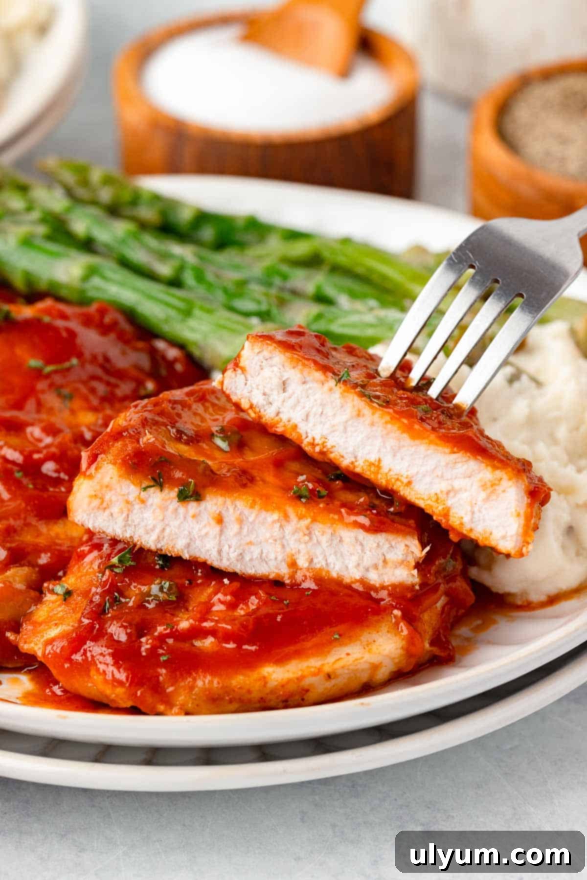 A bbq pork chop is cut in half to show they are perfectly cooked and tender.