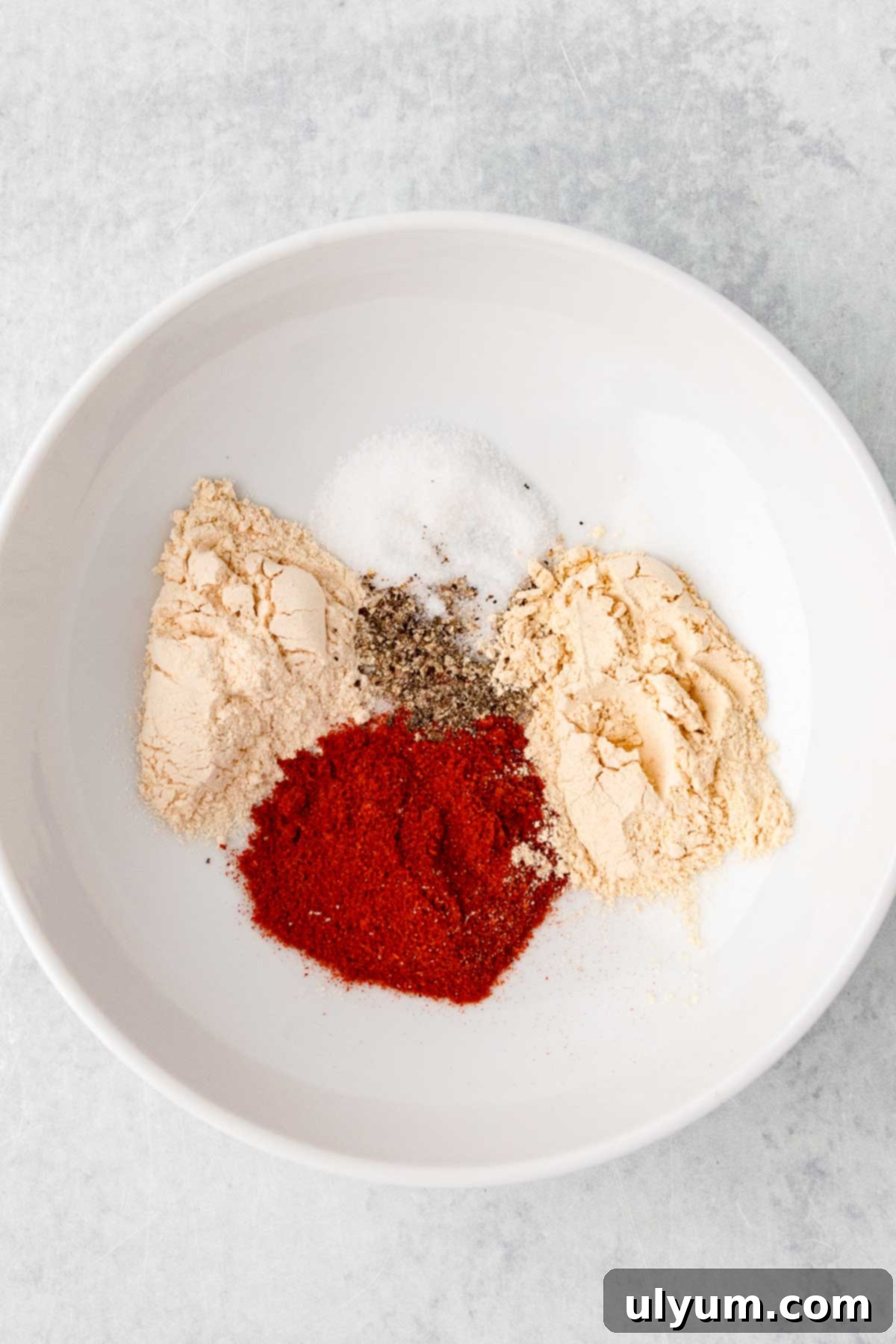 Garlic powder, onion powder, paprika, salt, and pepper in a small bowl.