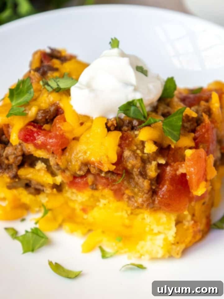 Mexican cornbread casserole topped with sour cream and cilantro.