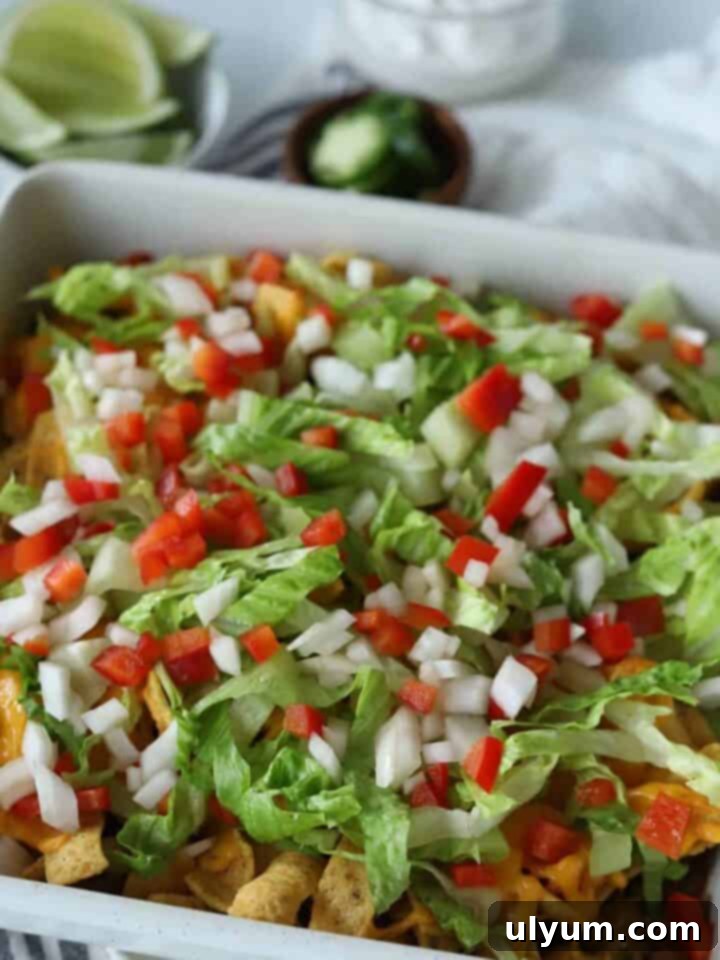 Walking Taco Casserole topped with fresh lettuce and tomatoes.