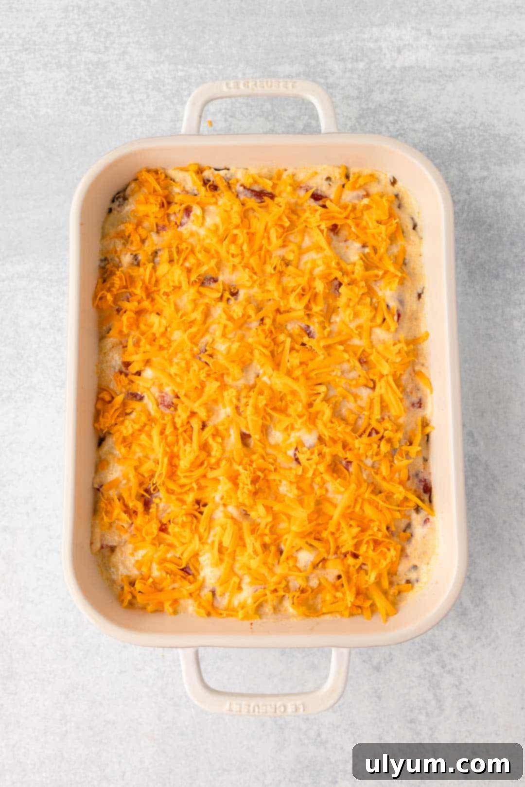 Remaining shredded cheddar is sprinkled over top of the casserole layers for a final cheesy touch.