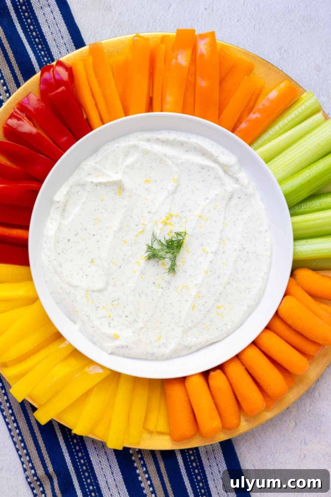 Creamy cottage cheese ranch dip served on a elegant platter, surrounded by a vibrant assortment of fresh, crisp vegetables including sliced red bell peppers, crisp carrots, and refreshing cucumber sticks, ready for dipping.