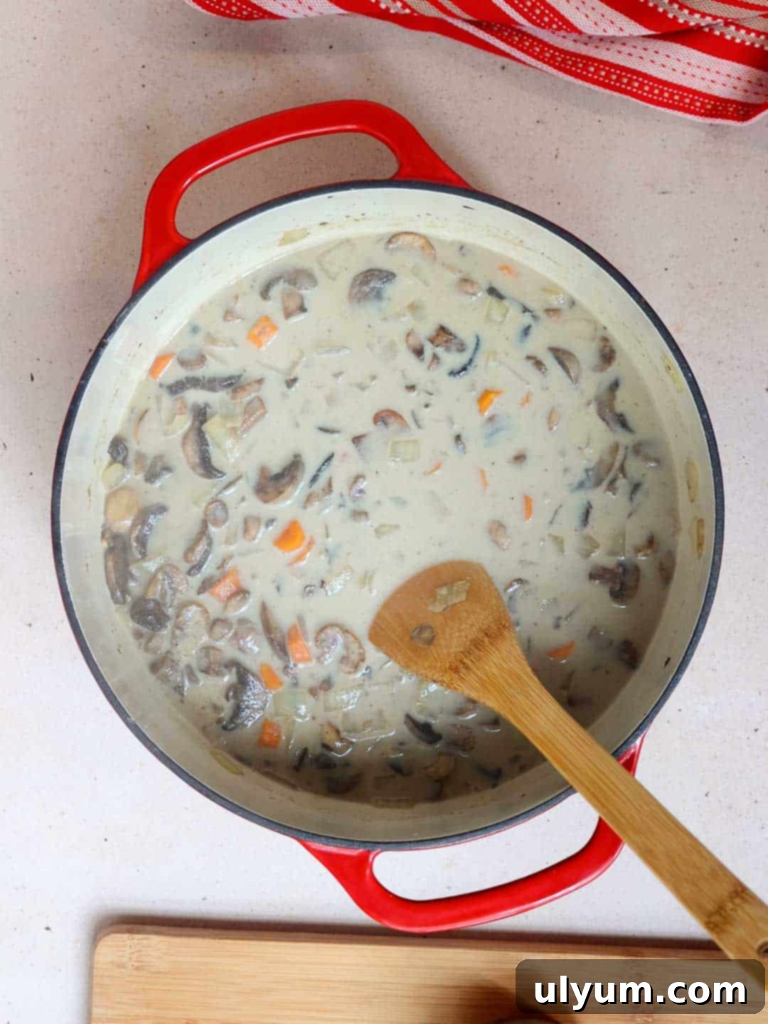 The mushroom and lentil soup simmering in a large pot, before the addition of milk and sour cream.
