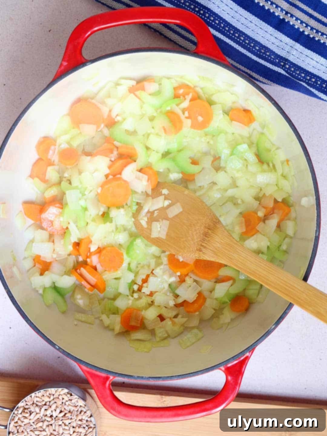 The veggies are cooked until softened and the onions are translucent in a large pot.