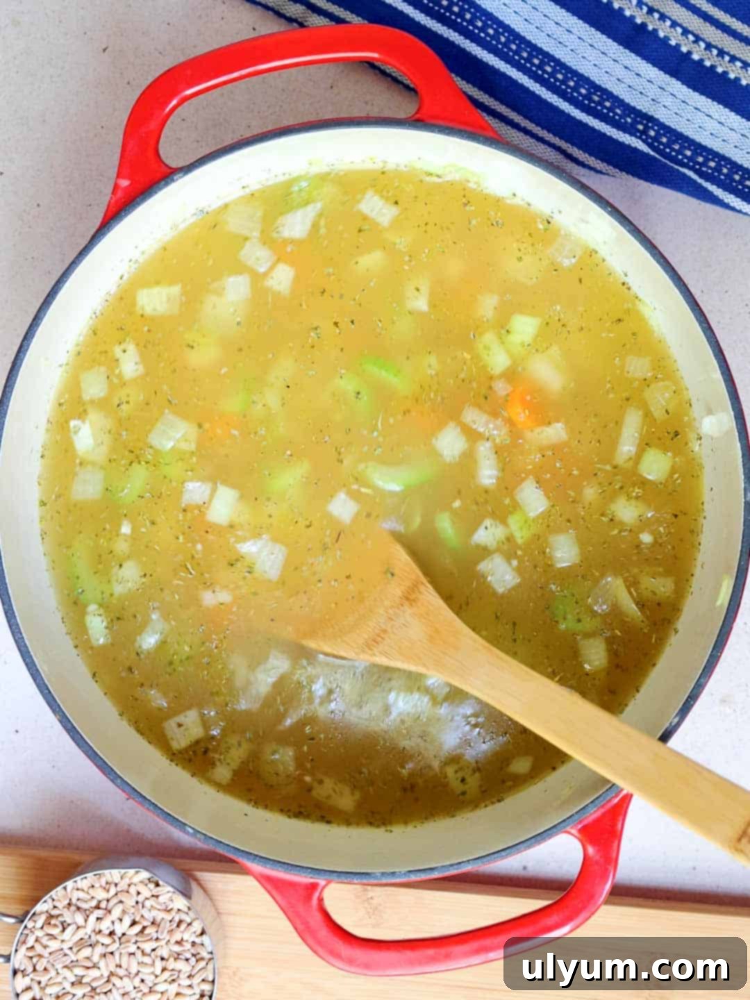 Broth and seasoning are added to the large pot.