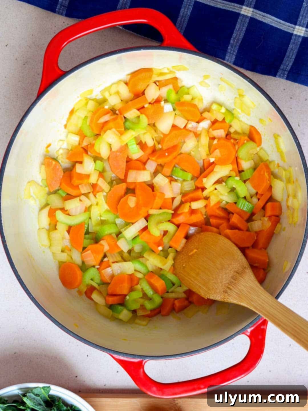 Diced onions, carrots, celery, and minced garlic are sautéed in a large pot with olive oil until softened and fragrant.