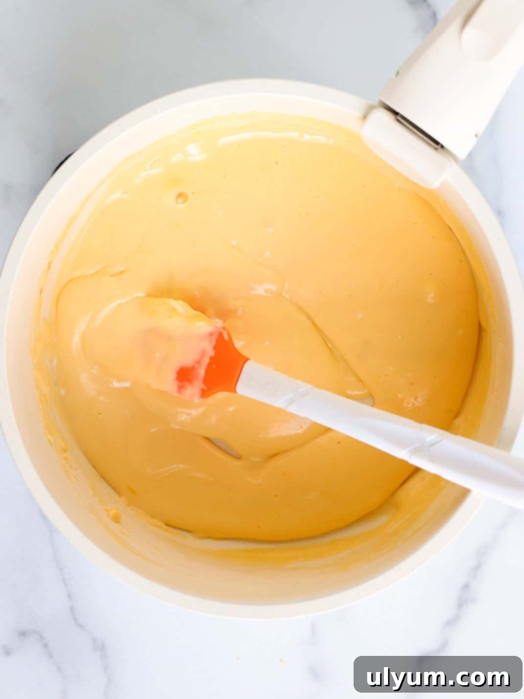 Creamy cheese, Velveeta, and heavy cream heated and stirred together in a medium saucepan until smooth.