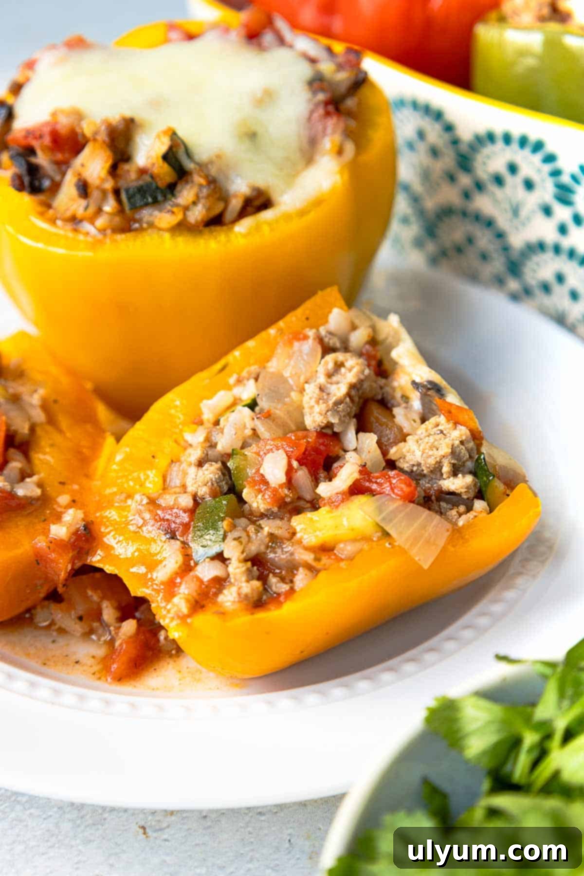 Hearty Ground Turkey and Rice Stuffed Peppers 12 A vibrant yellow bell pepper, perfectly baked and stuffed with a rich mixture of rice, ground turkey, and mixed vegetables, is cut in half to showcase its savory interior.