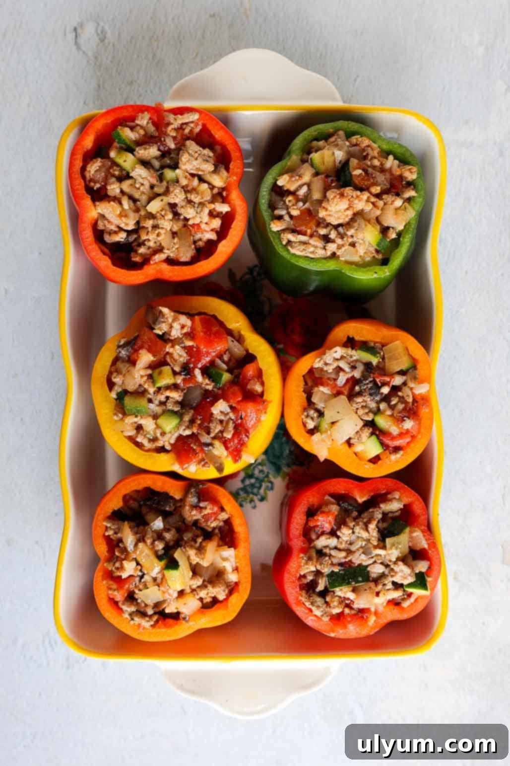 Hearty Ground Turkey and Rice Stuffed Peppers 8 Baking dish with six multicolored bell peppers generously stuffed until full with the savory ground turkey and rice mixture, ready to be covered and baked.