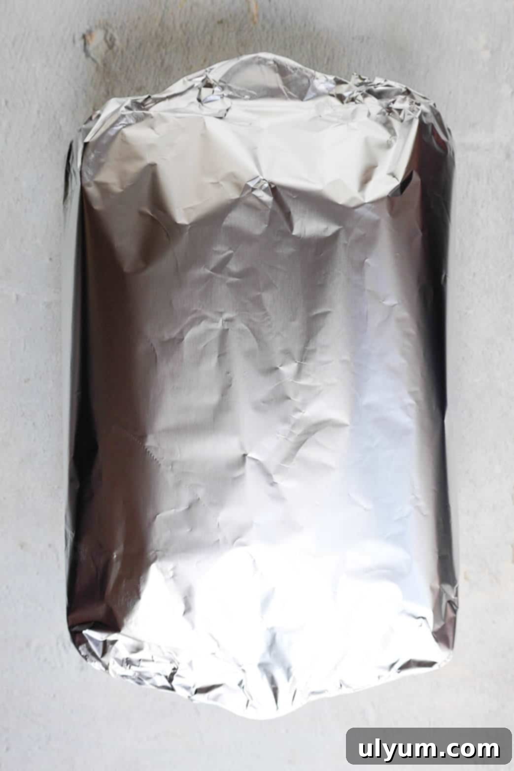 Hearty Ground Turkey and Rice Stuffed Peppers 9 A baking dish filled with stuffed bell peppers is tightly covered with aluminum foil, ready for baking to ensure even cooking and tender peppers.