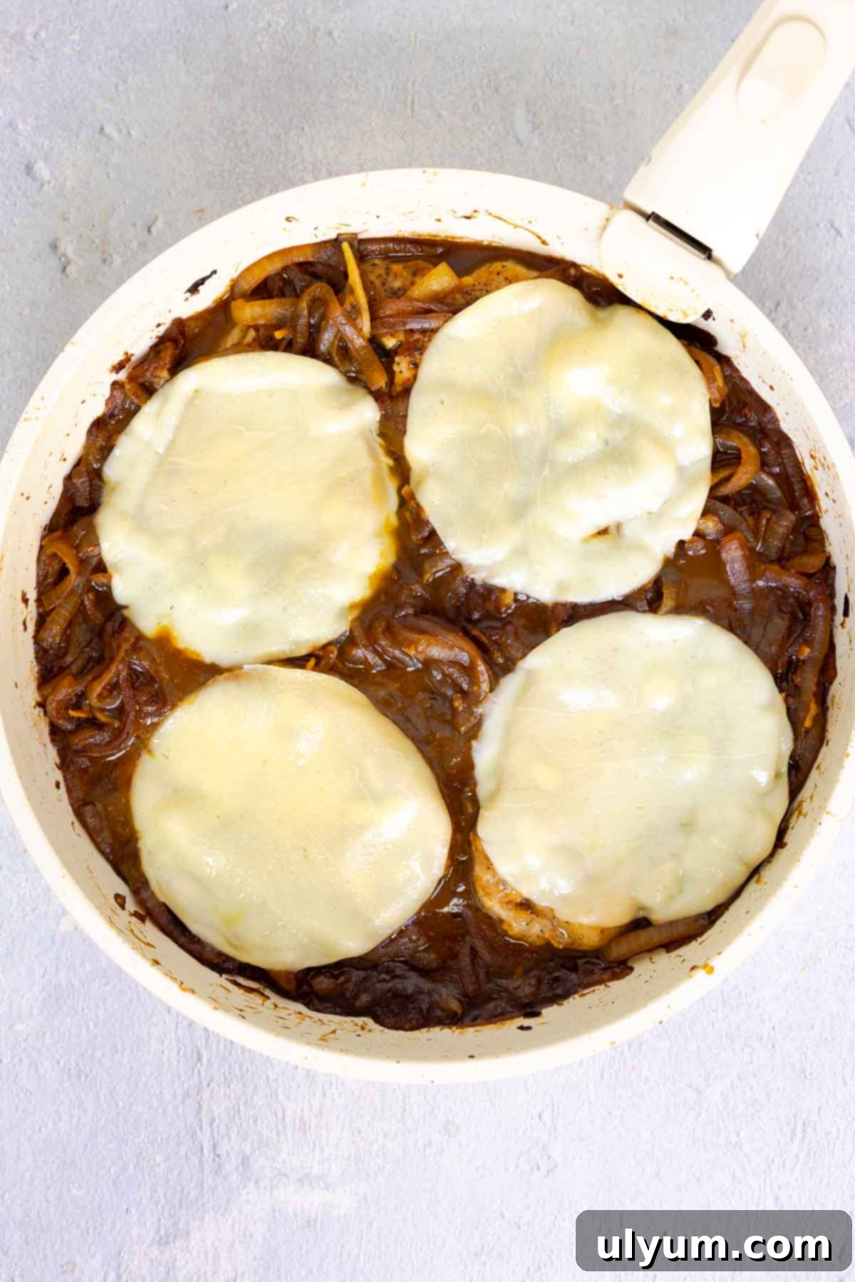 Savory French Onion Pork Chops 12 Pork chops in a skillet topped with melted provolone over a bed of caramelized onions.