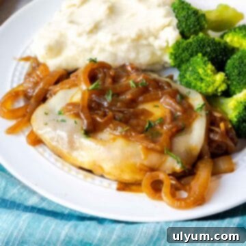 Savory French Onion Pork Chops 17 A pork chop topped with provolone and onions on a plate with mashed potatoes and broccoli.