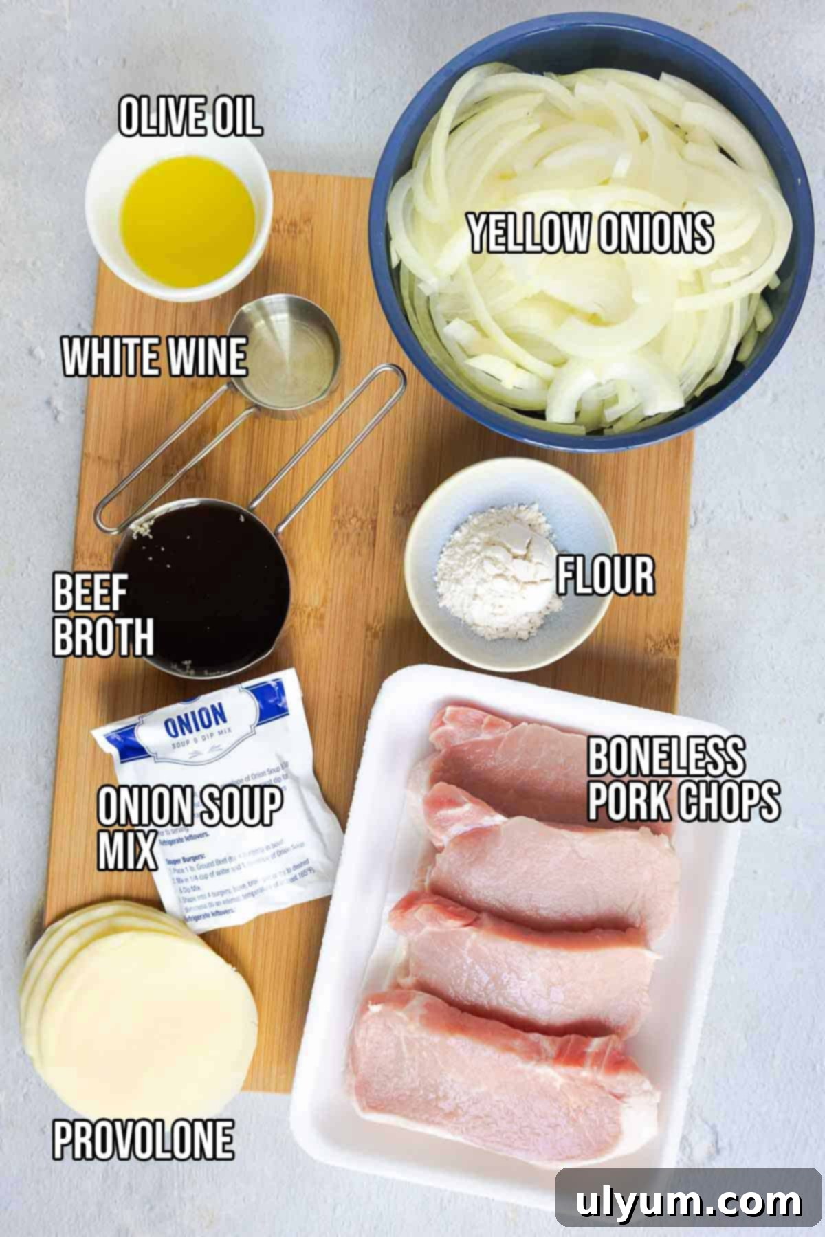 Savory French Onion Pork Chops 4 Ingredients on a board including pork chops, sliced onions, olive oil, white wine, beef broth, flour, provolone, and onion soup mix. Text on the image says 'OLIVE OIL', 'WHITE WINE', 'BEEF BROTH', 'ONION SOUP MIX', 'PROVOLONE', 'FLOUR', 'YELLOW ONIONS', 'BONELESS PORK CHOPS'.