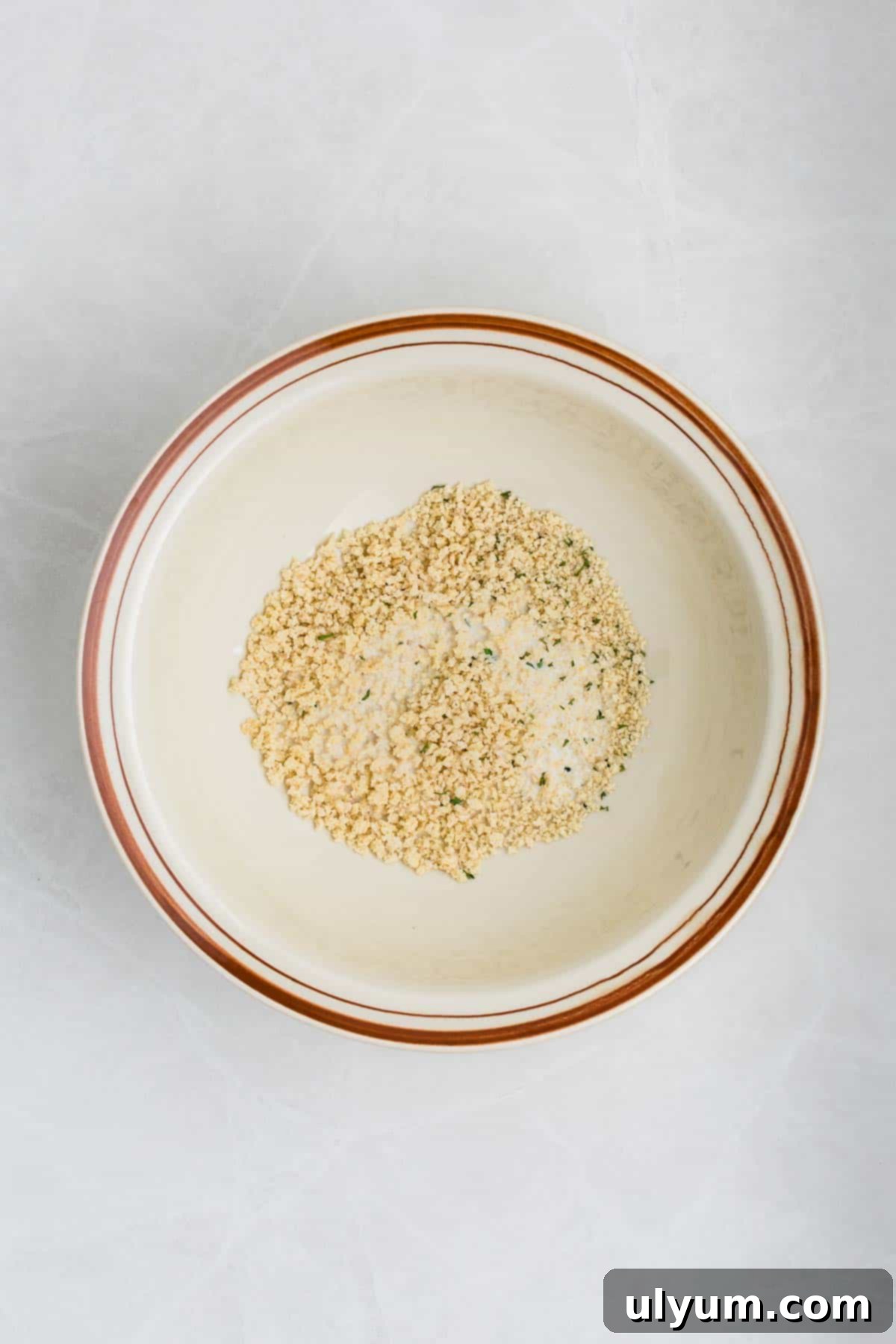 A bowl with panko breadcrumbs soaking in milk.